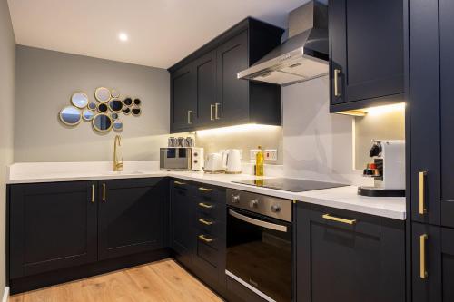 a kitchen with black cabinets and white counter tops at Host & Stay - Canning Quarters in Liverpool