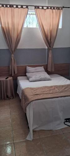 a bedroom with a bed with curtains on it at Hotel Cadore in Bauru