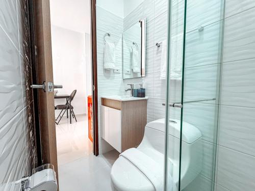 a bathroom with a toilet and a glass shower at Fee4Me Flat near Neomundo in Bucaramanga