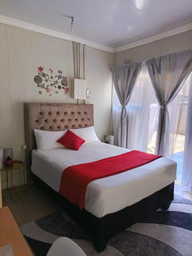 a bedroom with a large bed and a window at The Converted Space in Welkom