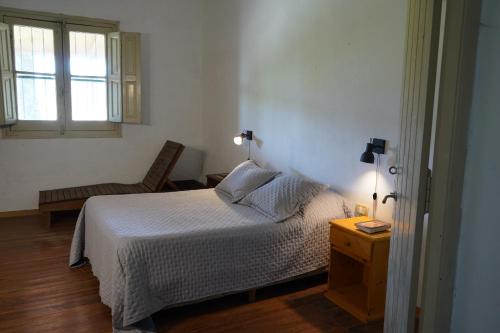 a bedroom with a bed and a chair and a window at Quinta San Miguel in Concordia