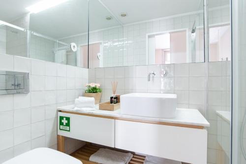 a white bathroom with a sink and a mirror at Get a Golden and Flower Flat in Porto
