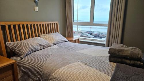 a bedroom with a bed with a view of the ocean at Beachfront Apartments in Sligo