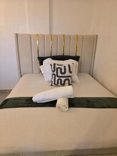 a bed with a towel and pillows on it at Misty Cabins in Ruringʼu