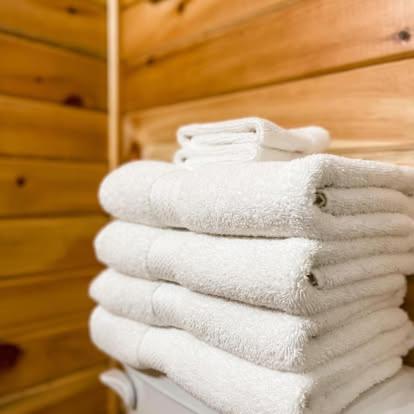 a stack of white towels sitting on top of a closet at Lawrencetown Lodge - The Maple Studio in Three Fathom Harbour