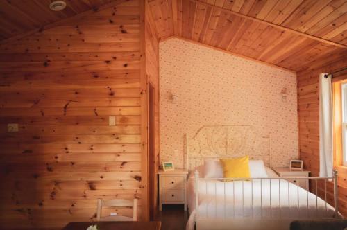 a bedroom with wooden walls and a bed in a room at Lawrencetown Lodge - The Maple Studio in Three Fathom Harbour