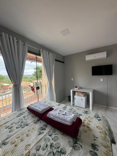 a bedroom with a large bed and a large window at Pousada Buganvília in Tianguá