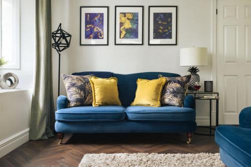 a blue couch with yellow pillows in a living room at Bellfoot Rural Retreat and Hot Tub in Grasmere