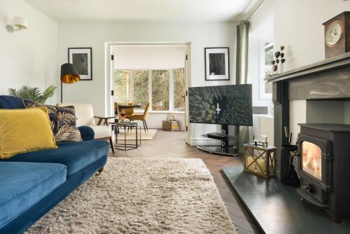 a living room with a blue couch and a fireplace at Bellfoot Rural Retreat and Hot Tub in Grasmere