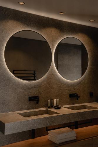 a bathroom with two sinks and two mirrors at Chalet Mirabell in Avelengo