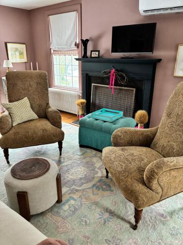 a living room with two chairs and a fireplace at House on the Gwynns Falls in Baltimore