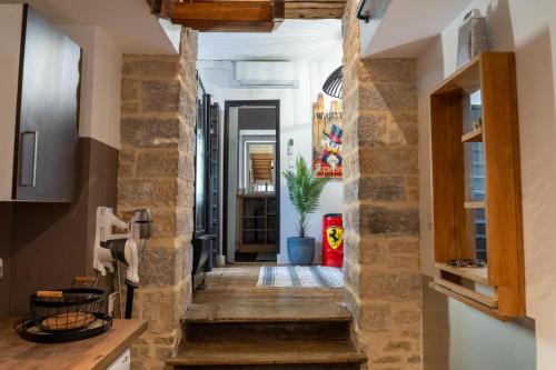 un couloir d'une maison avec des murs en pierre et un escalier dans l'établissement L'Atypique, à Dijon