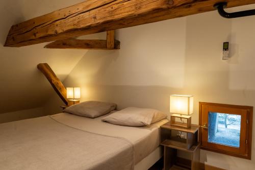 deux lits dans une chambre avec deux lampes sur les tables dans l'établissement L'Atypique, à Dijon