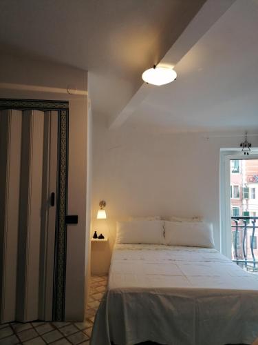a white bedroom with a bed and a window at la scogliera in Vernazza