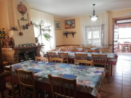 a dining room with tables and chairs and a room with a fireplace at La Vecchia Fontana in Penne