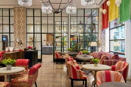 a restaurant with tables and chairs and windows at The Whitby Hotel in New York