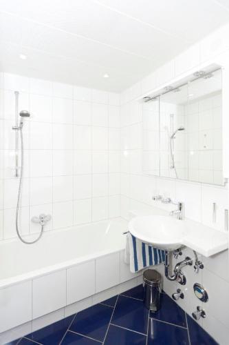a white bathroom with a sink and a tub at Tonis Appartement in Schruns