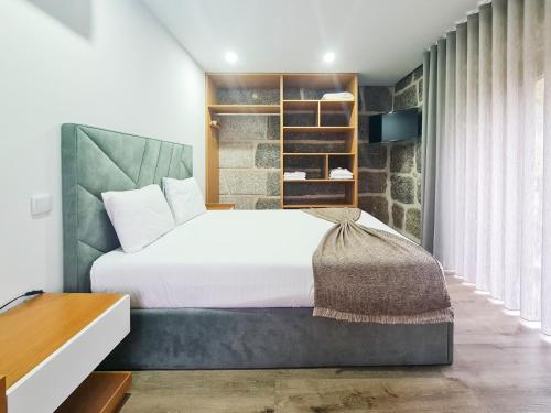 a bedroom with a large bed with white sheets at Casa d'Henrique Retreat Pool and Spa in Vieira do Minho