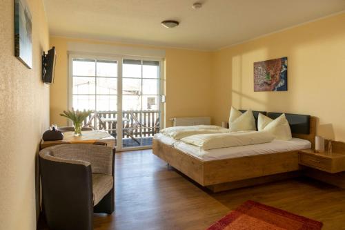 a bedroom with a large bed and a balcony at Parkpension Spreewald in Burg