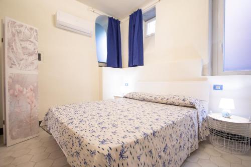 a bedroom with a bed and blue curtains at Il Nuovo Vecchio Frantoio di Gardan Con Piscina in Vignana