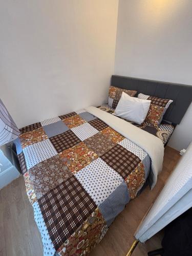 Super appartement في Malesherbes: غرفة نوم بها سرير مغطى ببطانية