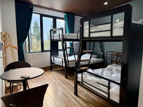 a room with bunk beds and a table and a table and chairs at Sapa Landscape Homestay in Sapa