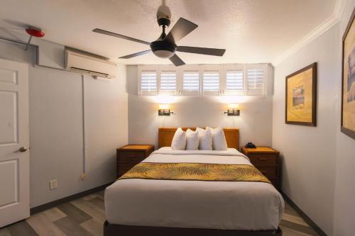 a bedroom with a bed with a ceiling fan at Kona Reef Resort by Latour Group in Kailua-Kona