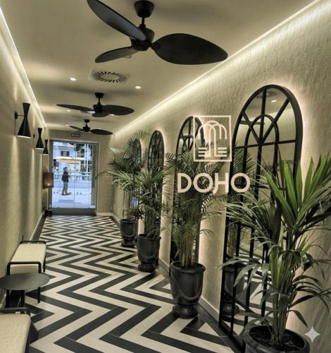 a lobby with potted plants and a sign on the wall at Hotel Doho in Málaga