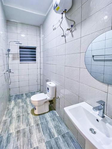 a bathroom with a toilet and a sink and a mirror at Premium Luxury Apartments in Abuja