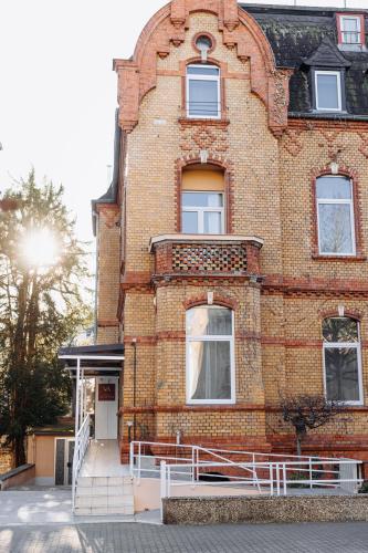 a brick building with a white fence in front of it at Hotel Kleiner Riesen in Koblenz