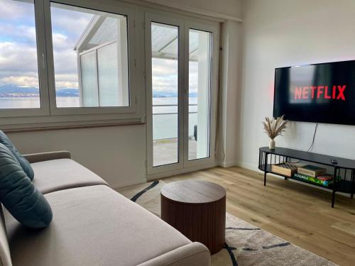 a living room with a couch and a flat screen tv at Horizon 62 I Zürich Lakeside Apartment I Modern I Free Parking I Self-Check-In in Richterswil
