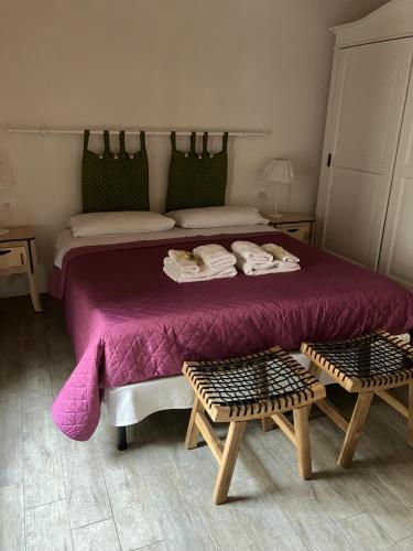 a bedroom with a purple bed with two chairs at Verso Est in Petralia Soprana