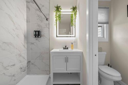 a bathroom with a toilet and a sink and a mirror at Blatchley Rooms by Yale in New Haven