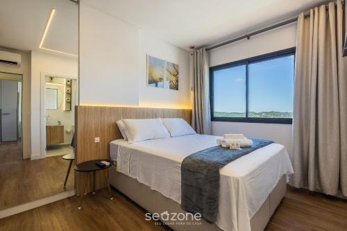 a bedroom with a bed and a large window at Apt w/ BBQ and Partial Ocean View ALE0803 in Piçarras