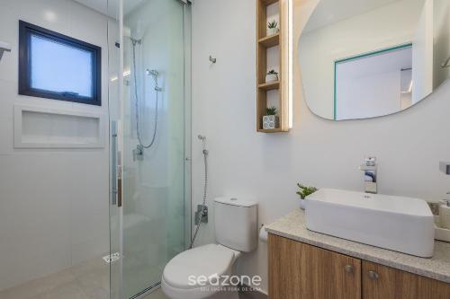 a bathroom with a toilet and a sink and a mirror at Apt w/ BBQ and Partial Ocean View ALE0803 in Piçarras