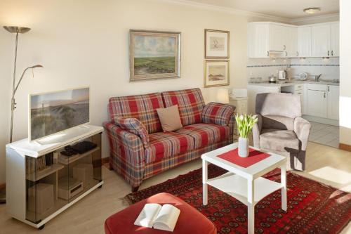 a living room with a couch and a table at Strandkieker in List