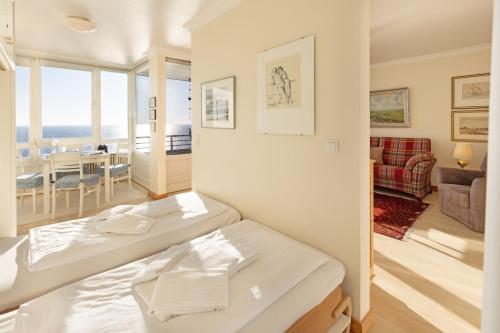 a bedroom with a bed and a living room at Strandkieker in List
