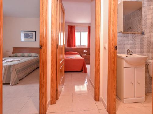 a bathroom with a sink and a bedroom with a bed at APCOSTAS Pereda Mar - Familiar in Puerto de Gandía