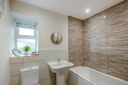 a bathroom with a tub and a sink and a toilet at 2 Bed in Benllech oc-t34071 in Benllech