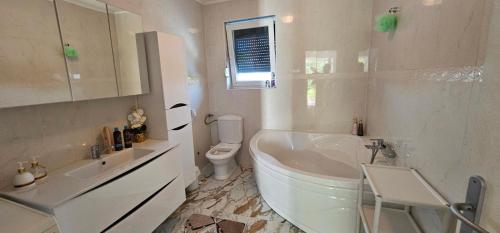 a bathroom with a tub and a toilet and a sink at Villa Aida in Cazin