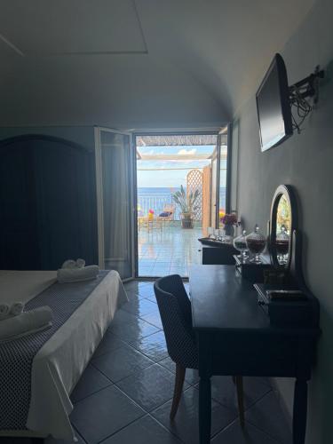 a bedroom with a bed and a table and a view of the ocean at Hotel Mezzatorre in Ventotene