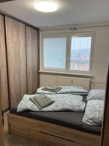 a bedroom with two beds and a window at Apartmán Leo in Kežmarok