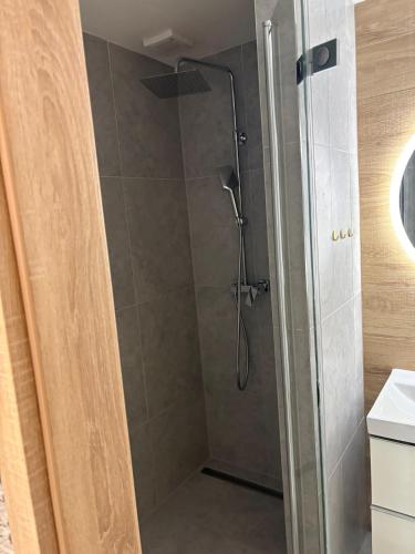 a shower with a shower head in a bathroom at Apartmán Leo in Kežmarok