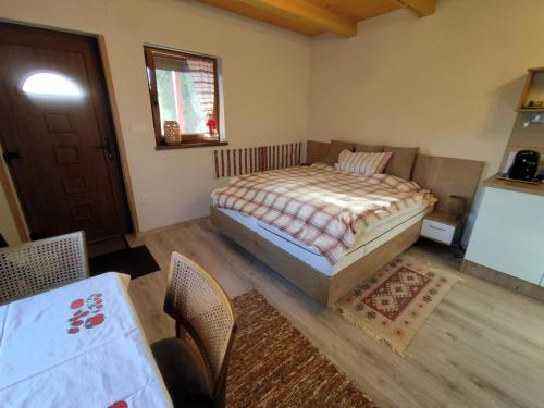 a bedroom with a bed and a table and chairs at Barna kuckó in Mohács