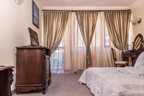a bedroom with a bed and a large window at Hotel Saint John Baptist Nessebar in Nesebar