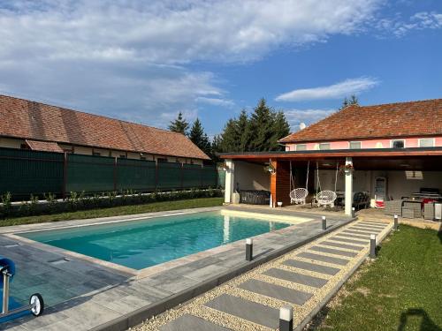a swimming pool in the backyard of a house at Somogyi Apartman Natur in Ciucsîngeorgiu