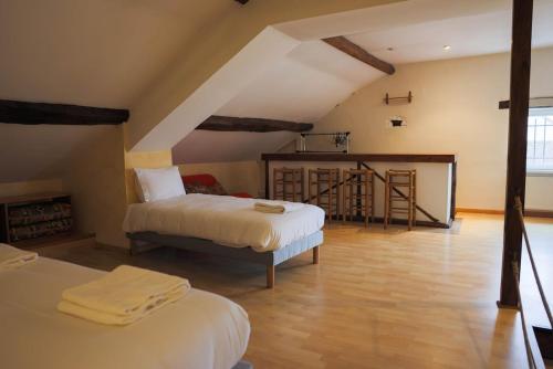 a attic room with two beds and a kitchen at L'Ancien Relais in Genouilly