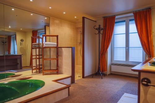 a bathroom with a tub and a sink and a mirror at L'Ancien Relais in Genouilly