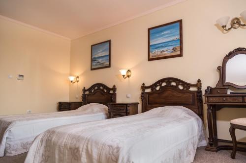a hotel room with two beds and a mirror at Hotel Saint John Baptist Nessebar in Nesebar