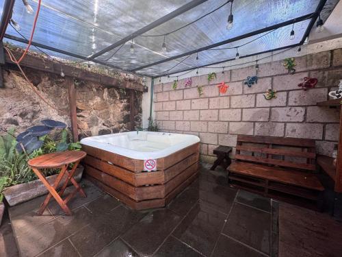 a bathroom with a bath tub and a wooden bench at Glamping en Valle de Bravo in Valle de Bravo